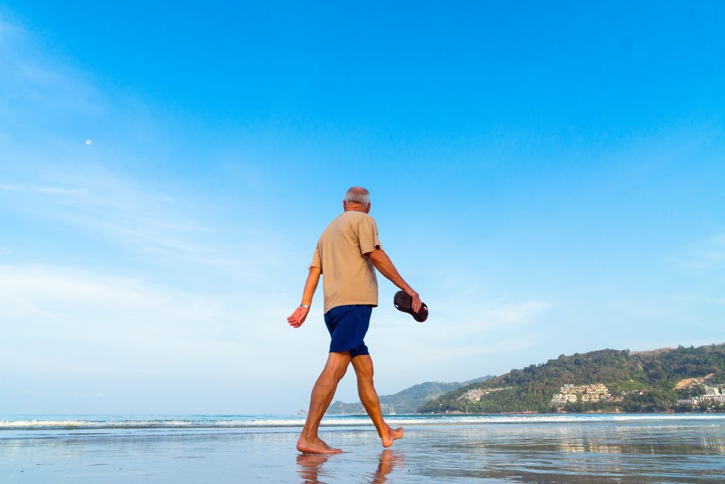 Senior man walking on beach