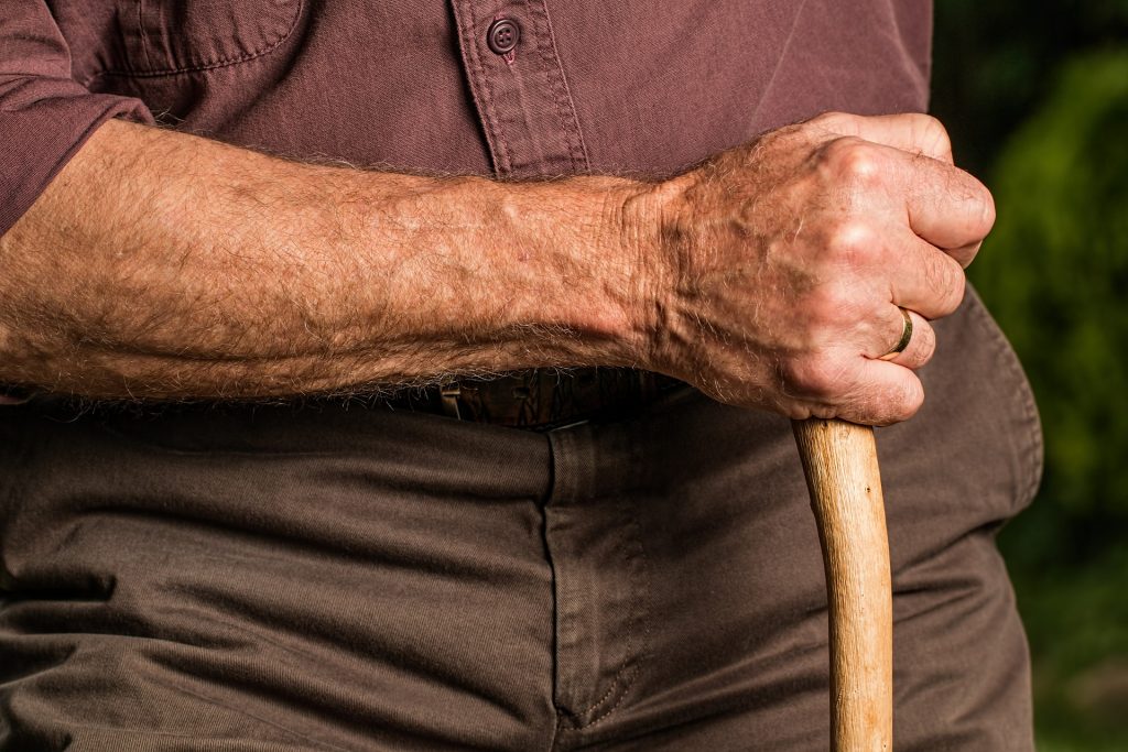 Elderly man holding cane